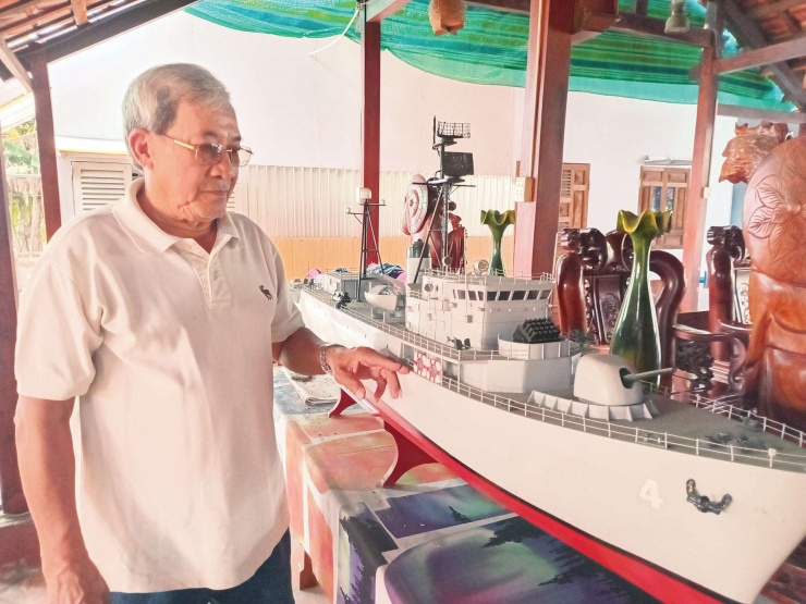 Ông Lữ Công Bảy bên cạnh mô hình tàu hải chiến mà ông từng làm giám hộ trên tàu. Ảnh: H.V