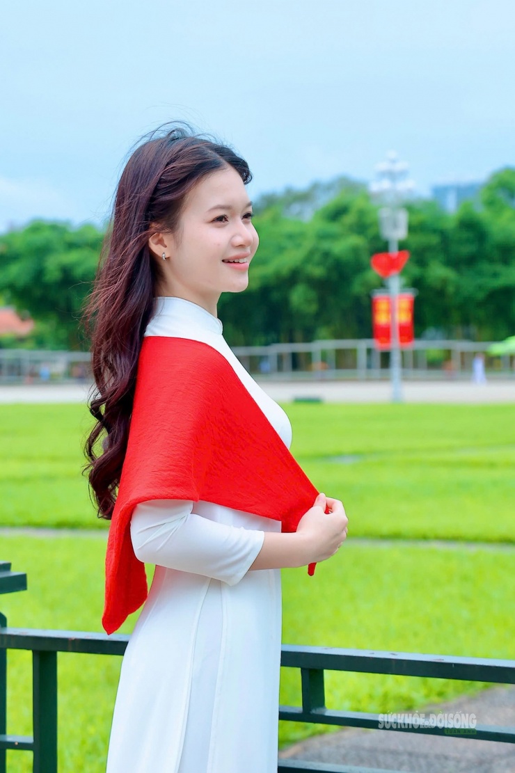 Một thiếu nữ khoác khăn đỏ lưu lại khoảnh khắc trong không gian xanh má.