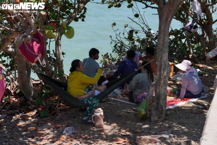 Bà Nguyễn Mỹ Phương (ngụ Đồng Nai) cho biết gia đình xuất phát từ sáng sớm bằng xe máy, tuy nhiên do quãng đường di chuyển và thời tiết nắng gắt nên khi đến nơi đã gần trưa. “Nắng quá, bãi biển không có chỗ tránh nên cả nhà phải mắc võng dưới gốc cây nghỉ tạm, chờ chiều mới xuống tắm,” bà Phương nói.