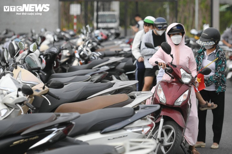 Từ cổng vào, bãi trông giữ xe không còn chỗ trống do lượng người đổ về tăng cao. Dưới thời tiết nắng nóng gần 30°C, nhiều gia đình vẫn kiên nhẫn chờ để vào tham quan.