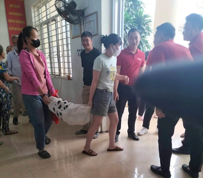 Người dân làm thủ tục tại nhà văn hóa, mang bao tải đựng tiền đền bù đất. Ảnh: UBND xã Thanh Oai