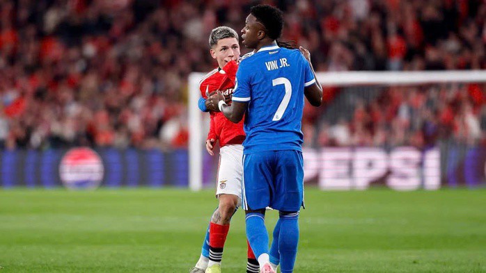 Gianluca Prestianni (áo đỏ) che miệng khi tranh cãi với Vinicius Junior trong trận play-off lượt đi hồi tháng 2 (Ảnh: AS)