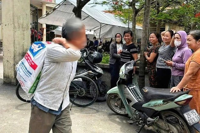 Một người dân mang bao tải đi đựng tiền đề bù đất. Ảnh: UBND xã Thanh Oai