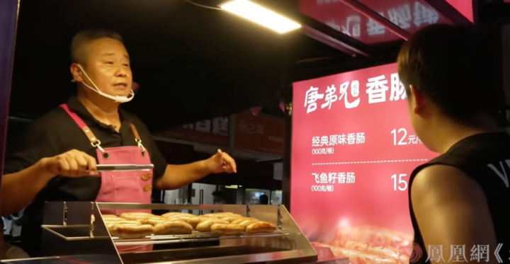 Đường Kiện tự mình ra đứng đường bán xúc xích kiếm tiền. (Ảnh: SCMP)