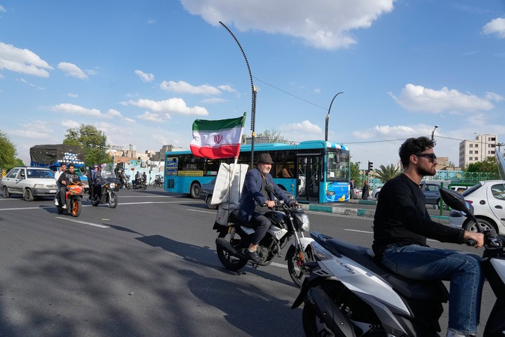 Một người đàn ông điều khiển xe máy với quốc kỳ Iran tại khu vực phía nam Tehran, Iran, ngày 21/4. (Ảnh: AP/Vahid Salemi)