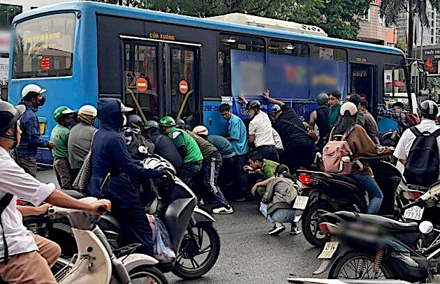 Vụ tai nạn giữa xe buýt và xe mô tô tại nút giao Nguyễn Văn Cừ - Nguyễn Sơn khiến một người phụ nữ bị thương, mắc kẹt dưới gầm xe buýt.