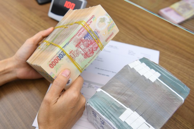 Giao dịch tiền tại một ngân hàng. Ảnh: Giang Huy