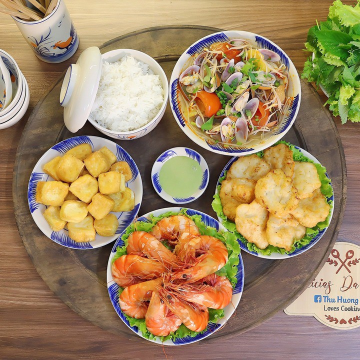 Mâm cơm có món tôm sú hấp nước dừa, chả mực, đậu phụ rán, canh chua ngao nấu dứa.