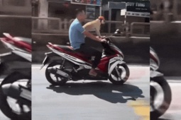 Người đầu trần chạy xe máy chở chó đội mũ bảo hiểm trên quốc lộ gây xôn xao