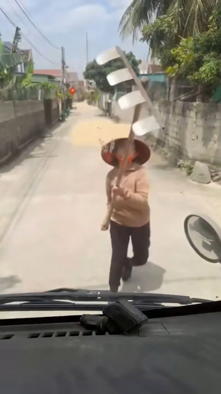 Phơi lúa lấn chiếm lòng đường, người phụ nữ dùng cào tấn công tài xế - 1