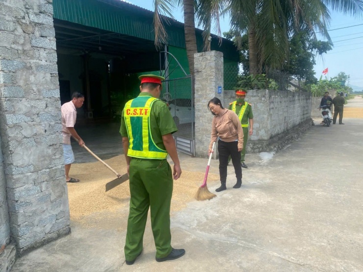 Công an yêu cầu bà Q. gom lúa phơi giữa đường. Ảnh: CACC