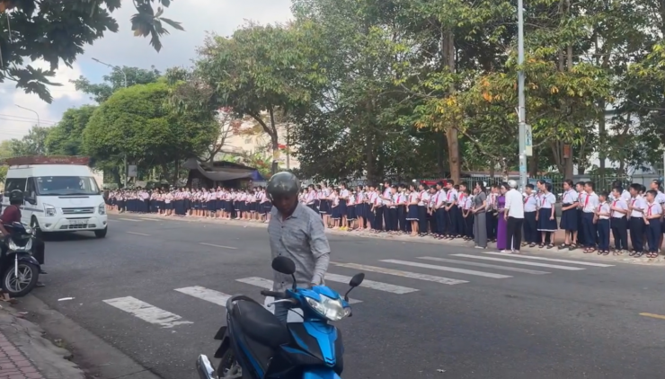 Hàng trăm học sinh tiểu học đứng ngay ngắn bên đường, nghiêng mình tiễn biệt lĩnh cữu thầy giáo. Ảnh cắt từ clip