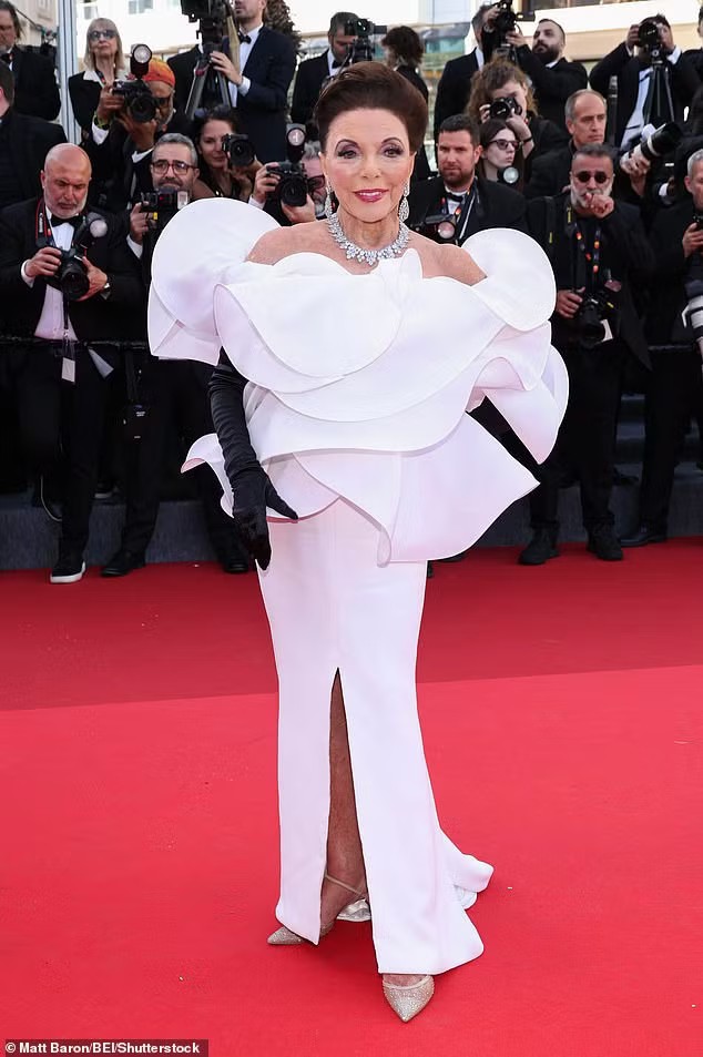 Nữ diễn viên gạo cội Joan Collins quyến rũ trong chiếc váy trắng, kết hợp cùng vòng cổ kim cương và găng tay đen. Đối với bà, tuổi 93 dường như chỉ là con số. Sánh đôi cùng Collins là chồng Percy Gibson (61 tuổi). Ảnh: WireImage/Shutterstock