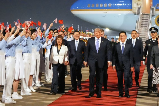 Tổng thống Mỹ Donald Trump đi cùng Phó Chủ tịch Trung Quốc Hàn Chính trong lễ đón tiếp tại sân bay quốc tế thủ đô Bắc Kinh hôm 13-5. Ảnh: AP