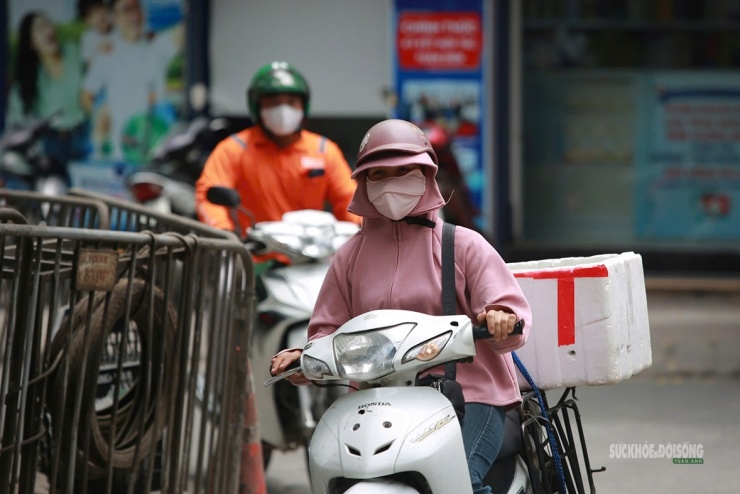 Người phụ nữ chở hàng rong kín mít giữa trưa nắng Hà Nội.