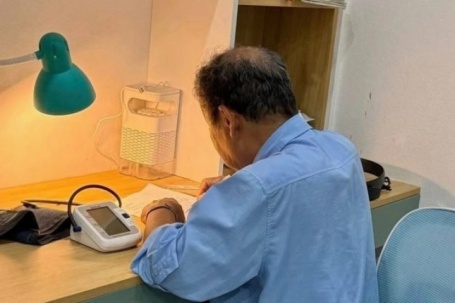 Ông 78 tuổi đặt máy đo huyết áp bên cạnh, kiên trì kèm cháu ôn thi vào lớp 10