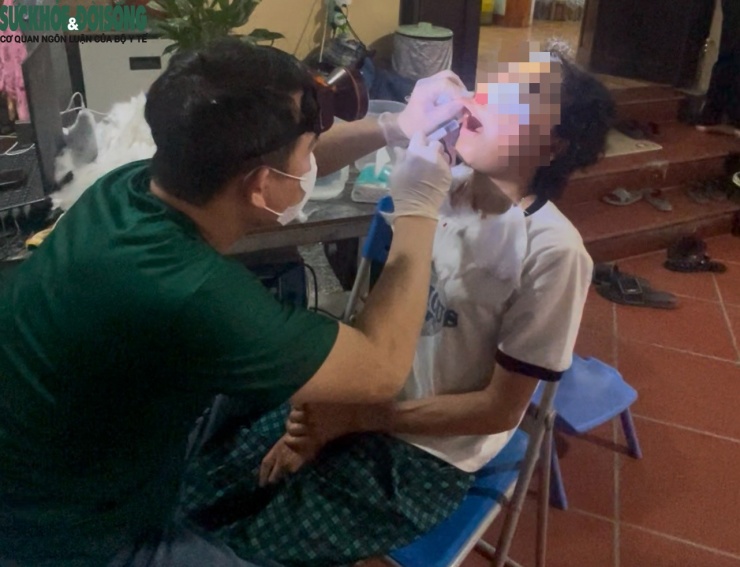 Sau khi can thiệp khối u trên khuôn mặt bệnh nhân, người đàn ông tiêm một chất gì đó vào lợi bệnh nhân để nhổ răng.