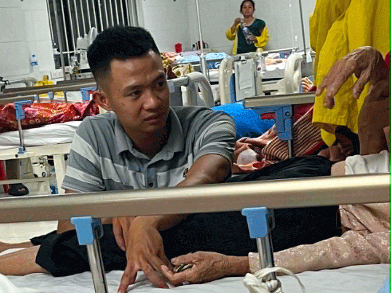Hình ảnh chàng trai chăm sóc bà nội U90 tại bệnh viện. Ảnh: Hoàng Trang