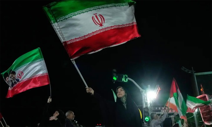 Người Iran mang theo quốc kỳ tham gia mít tinh tại thủ đô Tehran ngày 27/4. Ảnh: AP
