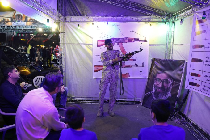 Sĩ quan Iran hướng dẫn người dân cách sử dụng súng tại gian hàng ở quảng trường Hafte Tir, Tehran, ngày 17/5. Ảnh: AFP