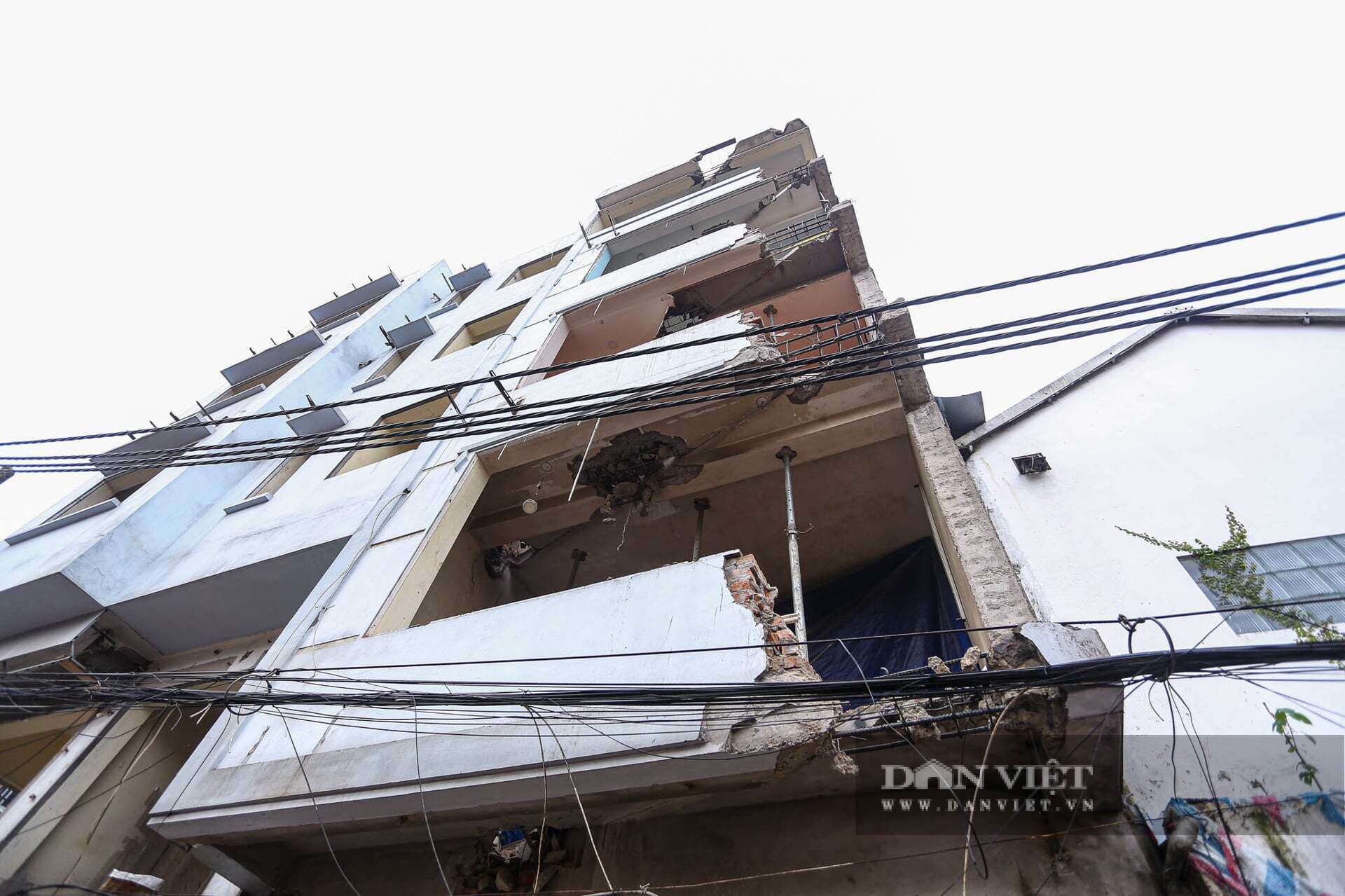 Căn nhà của bà Oanh bị cắt sâu khoảng 1,7 mét. Do công trình thi công ngay sát cửa, mỗi ngày bà phải quét dọn liên tục vì bụi bặm phủ kín lối vào. Để hạn chế bụi và đảm bảo sinh hoạt, gia đình bà còn phải hàn thêm cửa tôn che chắn phía trước nhà.