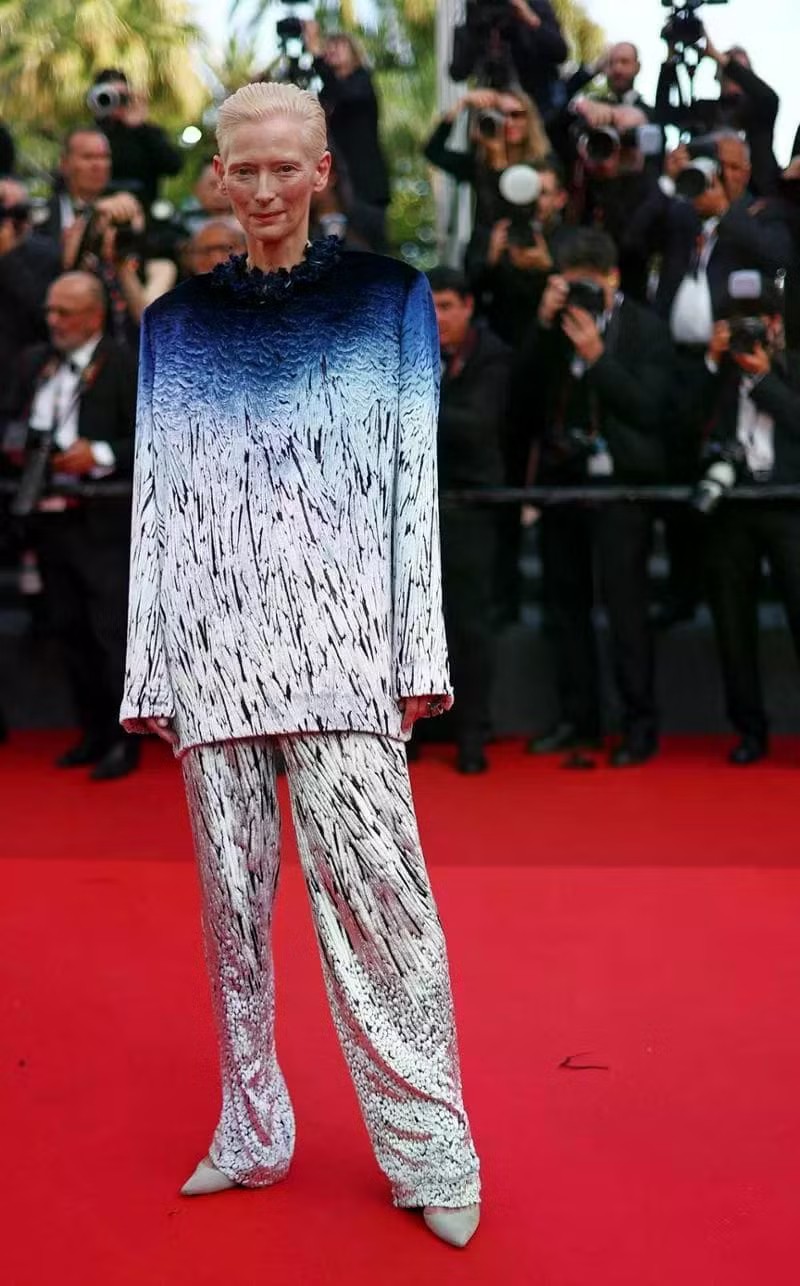Tilda Swinton chọn phong cách tinh tế với bộ suit quần chuyển sắc từ xanh sang bạc của Chanel, tạo hiệu ứng như lông vũ.