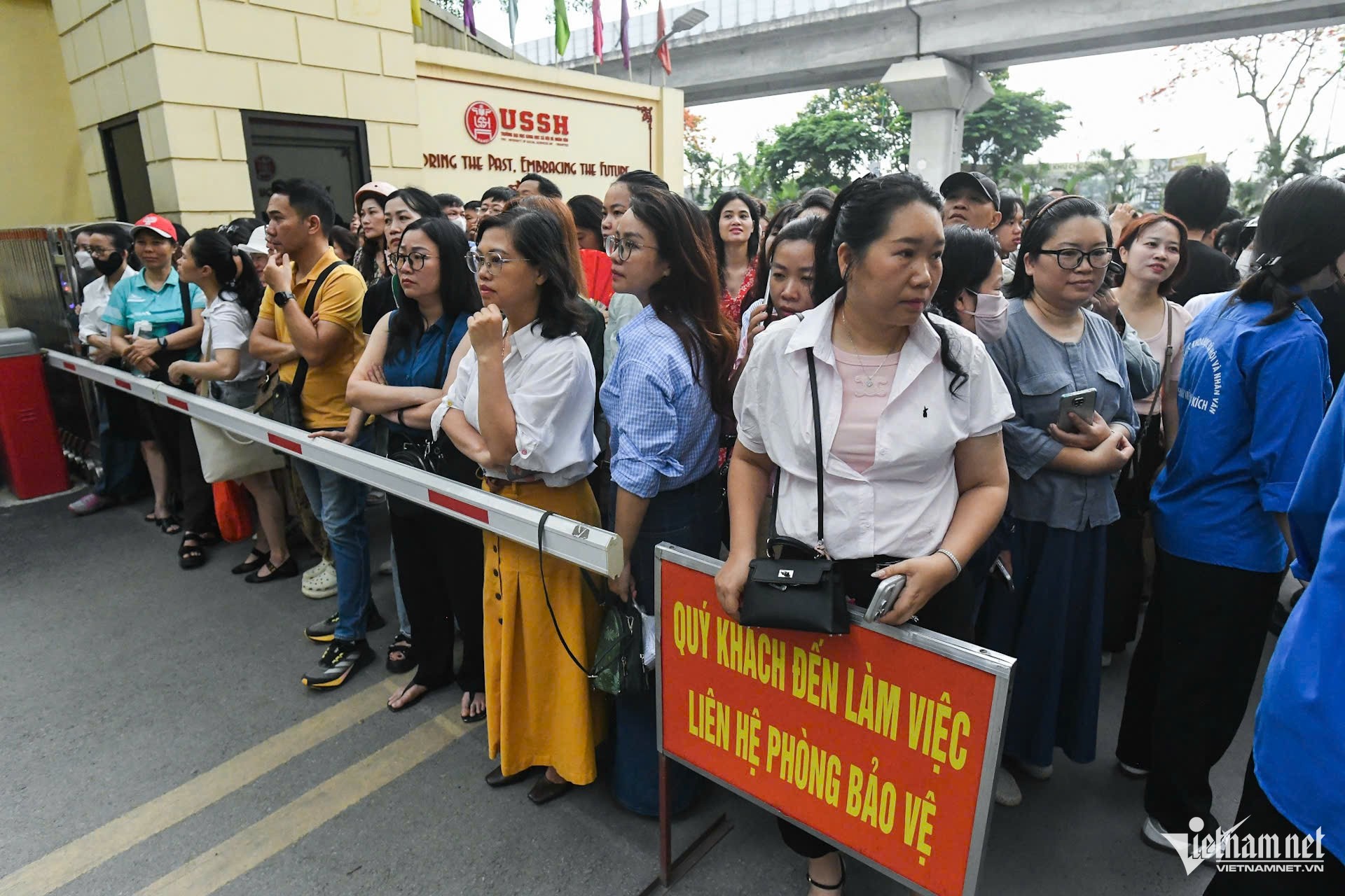 Phụ huynh thấp thỏm ngóng đợi con bên ngoài khu vực thi của Trường THPT Chuyên Khoa học Xã hội và Nhân văn. Ảnh: Thạch Thảo