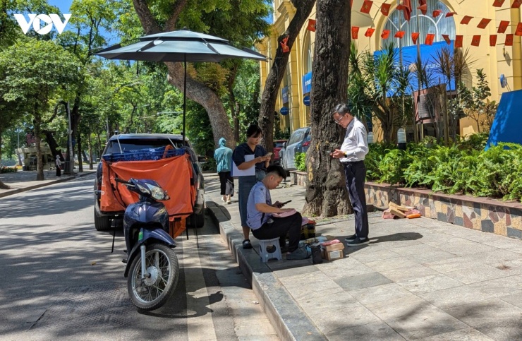 Để tránh nắng và bảo vệ hàng hóa, một shipper đã nghĩ ra cách che chắn tạm thời bằng chiếc ô tự chế gắn trên phương tiện di chuyển, nhằm giảm bớt tác động trực tiếp của ánh nắng.