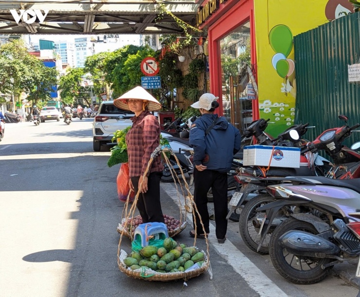 Chị Nguyễn Thị Hoài (ở Nhổn, Hà Nội) cho biết, những ngày nắng nóng kéo dài khiến sức khỏe suy giảm rõ rệt, đặc biệt trong khung giờ trưa. Dù mệt mỏi, chị vẫn phải duy trì việc bán hàng để có thu nhập trang trải sinh hoạt. Theo chị, hoa quả trong điều kiện nắng gắt cũng nhanh hỏng hơn, khiến việc buôn bán thêm khó khăn, mỗi ngày chị phải dậy từ rất sớm, gánh hàng đi bán và chỉ tranh thủ nghỉ dưới bóng râm khi quá mệt.