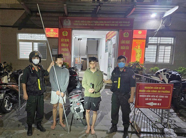 Các đối tượng Huy và Dũng cùng xe máy, hung khí tang vật tại cơ quan công an. Ảnh: Công an TP Hà Nội.