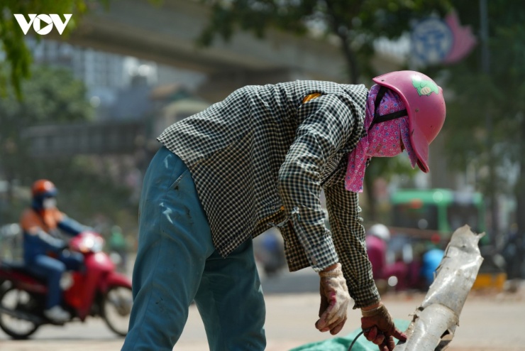 Giữa trưa nắng gắt, chị Thu (quê Tuyên Quang) cặm cụi đập bê tông, nhặt sắt vụn tại khu giải phóng mặt bằng đường Vành đai 2,5.