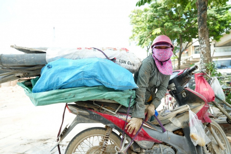 Những bao phế liệu cũ kỹ được chất cao lỉnh kỉnh phía sau chiếc xe máy cà tàng đã bạc màu theo năm tháng. Từ sắt vụn, nhựa, dây điện đến những mảnh nhôm cũ, tất cả được buộc chằng chịt trên yên xe để đem đến điểm thu mua phế liệu bán.