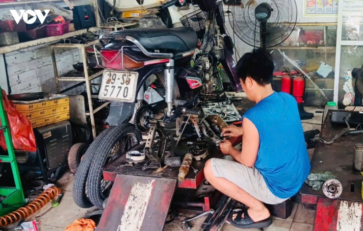 Anh Nguyễn Duy Tần đang bảo dưỡng cho một xe máy cũ.