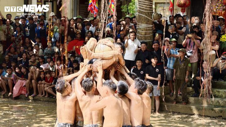 "Quân cầu" ôm quả gỗ mít được các trai làng nâng lên cao để tranh cuớp cầu.