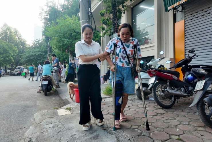 Chị Liên (áo chữ bên phải) được một phụ huynh cùng điểm thi chuyên THPT Nguyễn Huệ (Hà Đông) dìu ra chỗ ngồi.&nbsp;