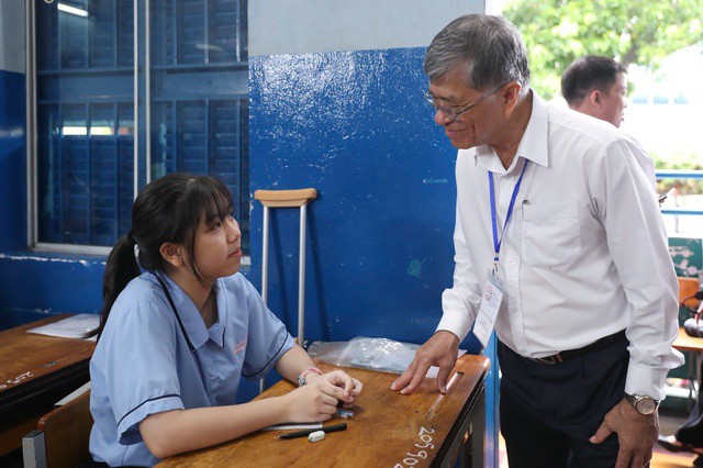 Tại điểm thi Trường THCS Lê Lợi, giám đốc Sở GD-ĐT TPHCM Nguyễn Văn Hiếu động viên tinh thần nữ sinh vì phải chống nạng đi thi