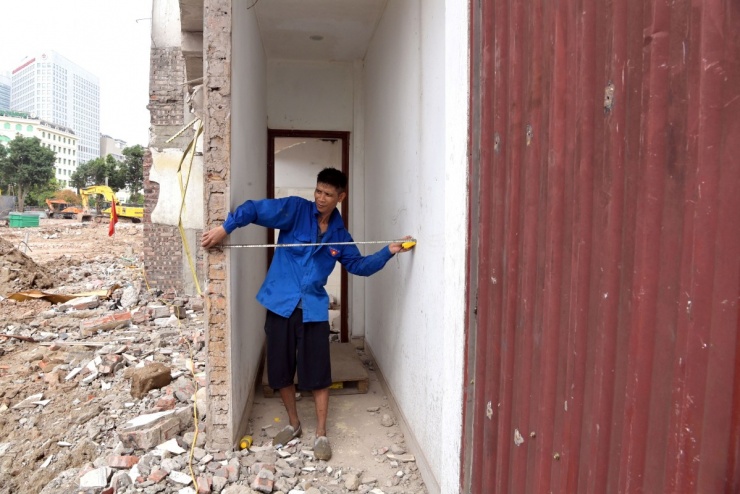 Trong ảnh, anh Triệu Thành, thợ xây được chủ nhà thuê để cải tạo căn nhà với chiều dài một mét, vừa đủ một người đi lại.