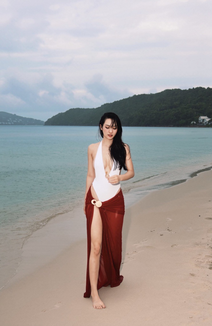 Giữa khung cảnh biển xanh, cát trắng và nắng vàng, người đẹp tự tin tạo dáng trước ống kính, thể hiện thần thái cuốn hút và phong cách chuyên nghiệp.