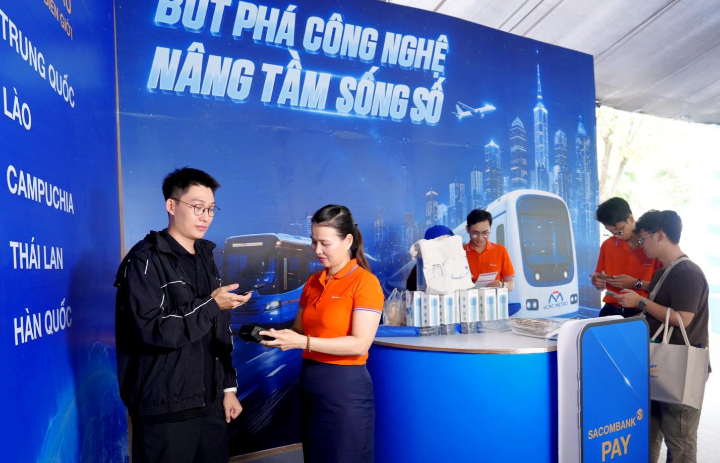 Một du khách Trung Quốc (góc trái) trải nghiệm dịch vụ thanh toán VIETQRGlobal ngay trên app Alipay tại gian hàng SACOMBANK sáng 6/6 - Ảnh: SACOMBANK