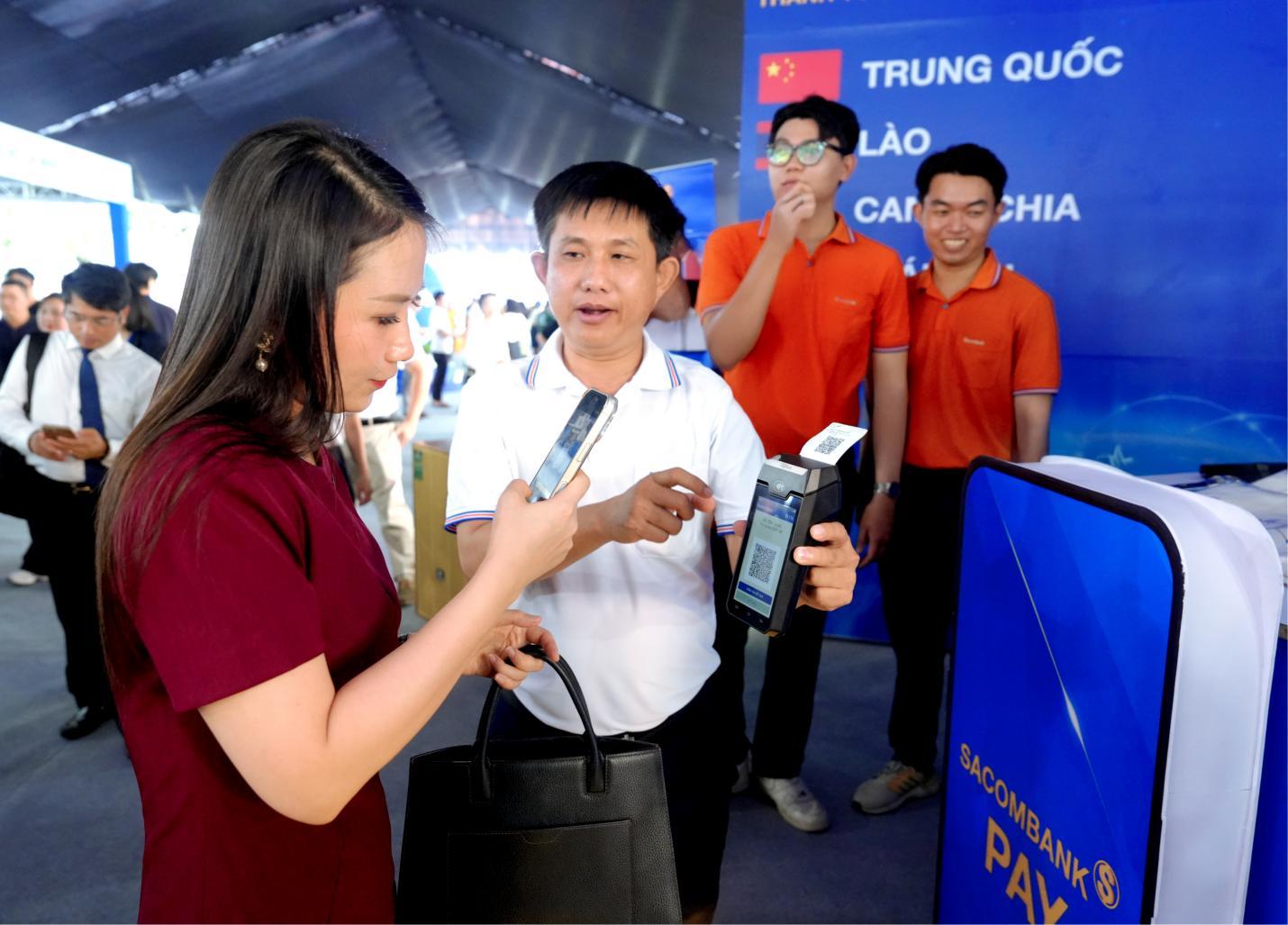 Khách tham quan quét mã VIETQRGlobal trên POS SACOMBANK - Ảnh: SACOMBANK