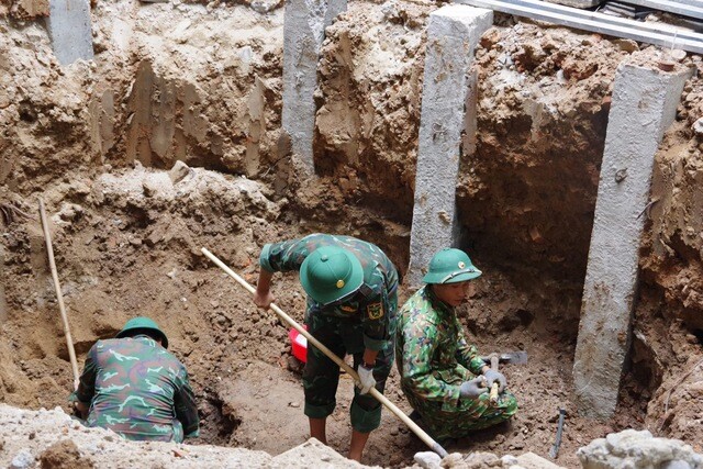 Lực lượng chức năng quy tập 4 hài cốt liệt sĩ tại công trường thi công bệnh viện. Ảnh: X.D.