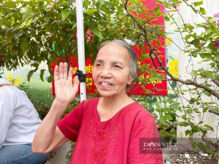 Dù cháu gái đã bước vào phòng thi và bắt đầu môn thi đầu tiên nhưng bà Đào Thị Phẩm ngồi nán lại ngồi bên ngoài cổng trường đợi cháu hoàn thành bài thi. Ảnh: Gia Khiêm