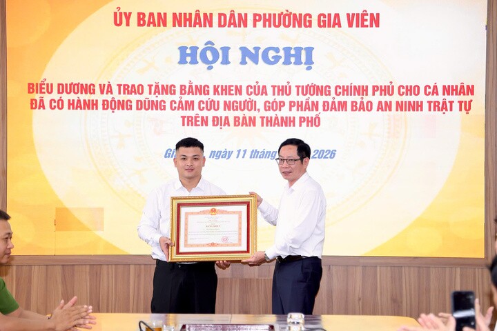 Ông Vũ Tiến Phụng, Phó Chủ tịch UBND TP Hải Phòng trao Bằng khen của Thủ tướng và tặng hoa chúc mừng anh Phạm Thế Huy Hoàng.