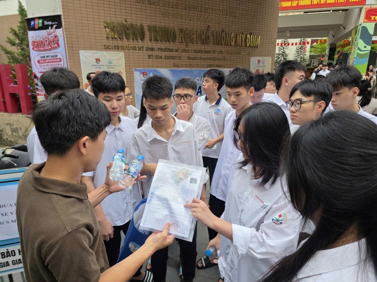 Học sinh trường THPT Trí Đức (trường nội trú) được giáo viên phát hồ sơ dự thị trước điểm thi trường THPT Mỹ Đình, sáng 11/6. Ảnh: Thanh Hằng