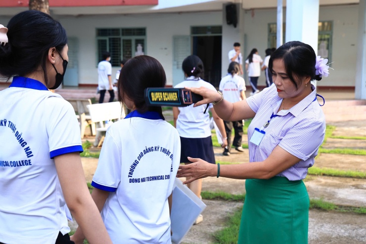 Thí sinh trường THPT Trấn Biên, Đồng Nai, được nữ giám thị quét kiểm tra an ninh, trước khi vào phòng thi. Ảnh: Phước Tuấn