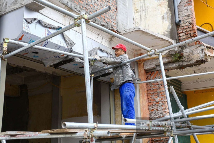 Công nhân xây dựng tiến hành gia cố mặt tiền cho ngôi nhà vừa bàn giao một phần diện tích phục vụ dự án.