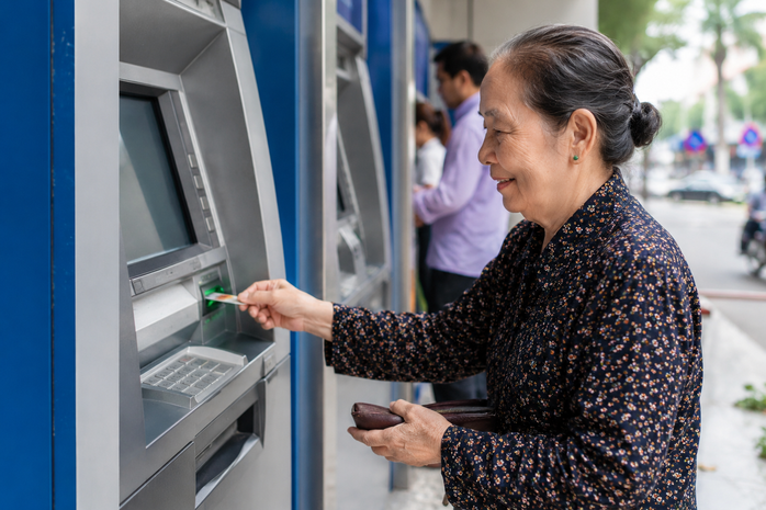 Người hưởng lương hưu nhận tiền qua tài khoản cá nhân tại cây ATM. Ảnh minh hoạ