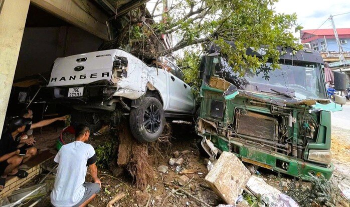 Hiện trường chiếc xe tải mất lái tông hư hỏng ô tô bán tải, làm bật gốc cây lộc vừng