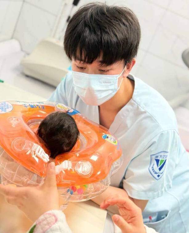Zhang Jintao hướng dẫn chăm sóc sức khỏe cho trẻ sơ sinh. Ảnh: Guancha