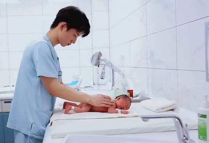 Zhang Jintao masage cho một em bé sơ sinh. Ảnh: Weixin